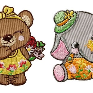 May include: Two embroidered iron-on patches featuring a brown bear holding flowers and a grey elephant holding a flower. Both patches have yellow and orange floral details.