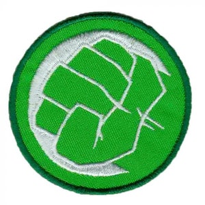Könnte beinhalten: Grüner und weißer gestickter Aufnäher mit einem Kreisdesign. Der Kreis hat eine weiße Faust darin.
