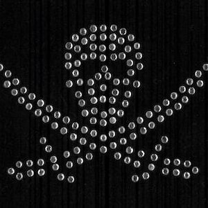 Könnte beinhalten: Ein silbernes Totenkopf- und Knochenkreuz-Design aus Strasssteinen auf schwarzem Hintergrund.