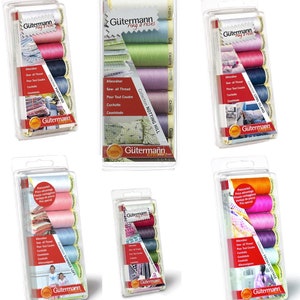 Könnte beinhalten: Sechs Packungen Gutermann-Garn in verschiedenen Farben. Jede Packung enthält fünf Garnrollen und trägt den Namen einer anderen Kollektion, wie "Long Island" und "French Cottage".
