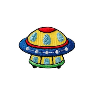 May include: A colorful embroidered patch of a cartoon UFO with a yellow dome, blue bottom, and red and white accents.