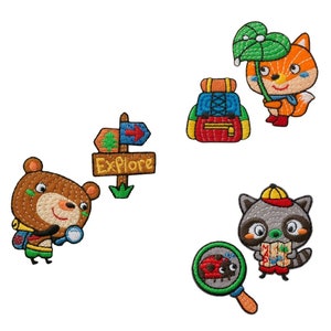 Può includere: Cinque toppe ricamate da stirare che raffigurano un orso bruno con una lente d'ingrandimento, un cartello con la scritta "Esplora", una volpe con un ombrello a foglia verde, uno zaino rosso e un procione con una mappa e una lente d'ingrandimento.