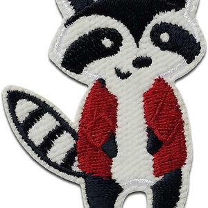 Könnte beinhalten: Aufbügel-Patch mit einem Cartoon-Waschbären, der eine rote Jacke trägt. Der Waschbär hat ein schwarz-weißes Gesicht mit einer schwarzen Nase und schwarzen Augen. Der Waschbär hat einen weißen Körper und einen schwarz-weiß gestreiften Schwanz.