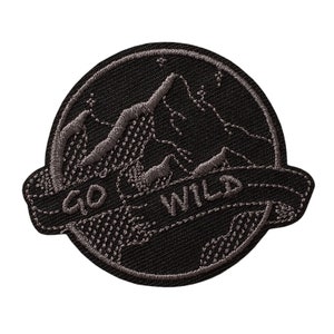 Könnte beinhalten: Schwarzer gestickter Aufnäher mit einem Bergketten-Design und dem Text "GO WILD" in einem Banner.