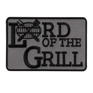 Könnte beinhalten: Rechteckiger Aufnäher mit den Worten "LORD OF THE GRILL" in Schwarz auf grauem Hintergrund gestickt. Das Design beinhaltet einen Grill und gekreuzte Grillwerkzeuge.