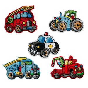 Op de afbeelding: Vijf geborduurde strijkpatches met verschillende voertuigen: een rode brandweerwagen, een blauwe tractor, een zwart-witte politieauto, een blauwe kiepwagen en een rode sleepwagen.