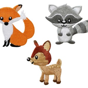May include: Three embroidered iron-on patches featuring a fox, a raccoon, and a deer. The fox is orange with a white chest and tail tip. The raccoon is grey with a white chest and a black and grey striped tail. The deer is brown with a white chest and a white spot on its back.