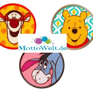 May include: Three embroidered patches featuring cartoon characters. One shows Tigger with a red border and yellow polka dot background. Another features Winnie the Pooh with a teal and white pattern. The third patch depicts Eeyore.