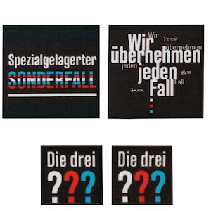 Könnte beinhalten: Vier schwarze Stoffpatches mit weißem Text und roten, blauen und weißen Akzenten. Der obere linke Patch sagt "Spezialgelagerter SONDERFALL". Der obere rechte Patch sagt "Wir übernehmen jeden Fall". Die unteren linken und rechten Patches sagen "Die drei ???" mit drei Fragezeichen in Rot, Blau und Weiß.