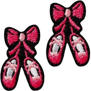 Könnte beinhalten: Zwei gestickte Aufnäher von rosa Ballettschuhen mit schwarzen Umrissen und rosa Schleifen. Die Schuhe haben weiße Akzente und sind mit detaillierten Nähten versehen, ideal zum Aufnähen auf Kleidung oder Accessoires.