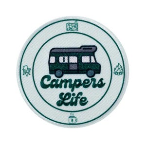 Könnte beinhalten: Ein runder, gestickter Aufnäher mit helltürkisfarbenem Hintergrund und dunkelgrünem Rand. Der Aufnäher zeigt eine Wohnmobil-Grafik und die Worte "Campers Life" in einer Schriftart. Zusätzliche Camping-Symbole umgeben das zentrale Design.