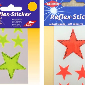 May include: Two packages of reflective star stickers. The package on the left has green stars with a glittery border. The package on the right has red stars with a black border. Both packages have the text "Reflex-Sticker" and "Quick" on them.