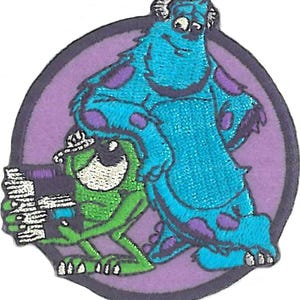 May include: A purple circle with a blue monster with purple spots and a green one-eyed monster with a purple hat. The blue monster is standing on the green monster's back.