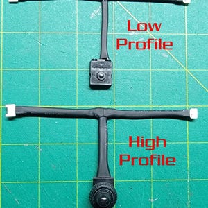 May include: Two black electronic components with white connectors and the text "Low Profile" and "High Profile" in red. The components are on a green cutting mat.