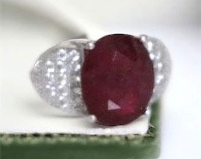 Ruby and white Topaz ring on 925 sterling band.  Marked S925, 3 Carat Oval Lab ruby stone.