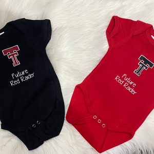 May include: Two baby onesies, one black and one red, with a white embroidered Texas Tech University logo and the text "Future Red Raider".