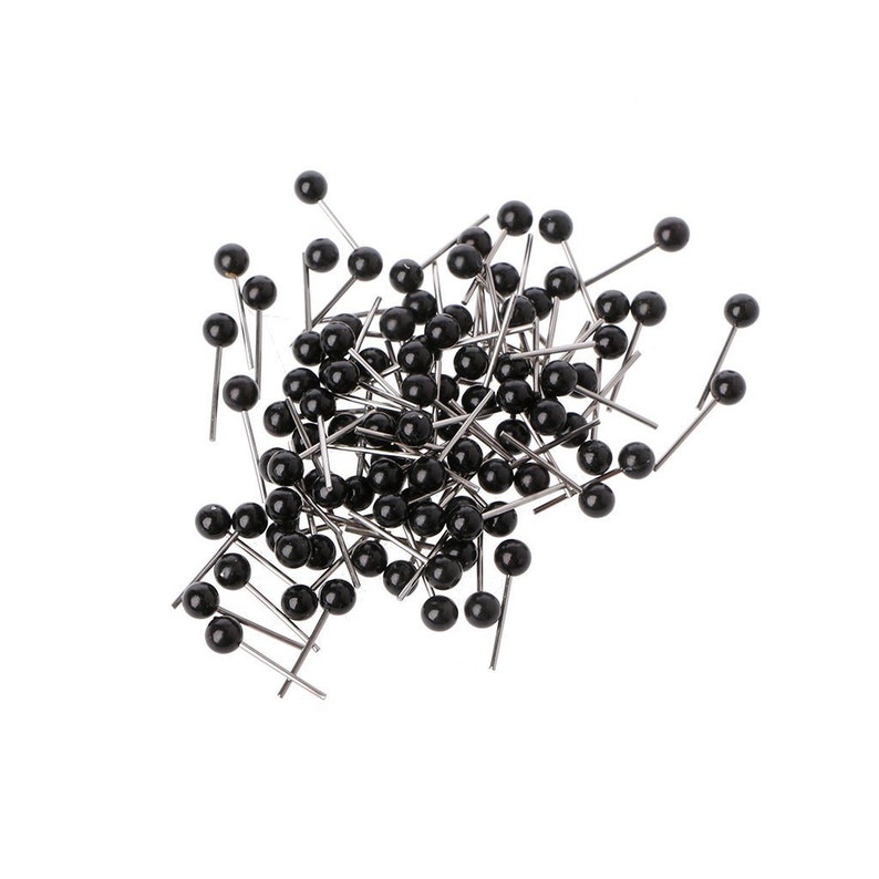 May include: A pile of black headed push pins with silver metal shafts.