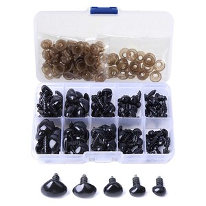 May include: A clear plastic storage box filled with black plastic safety eyes and brown plastic washers. The box has 10 compartments and is organized by size. The safety eyes are in various sizes and have a black plastic washer on the back.