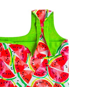 May include: A green and white reusable shopping bag with a watermelon print. The bag has a green fabric lining and a wide, flat base.