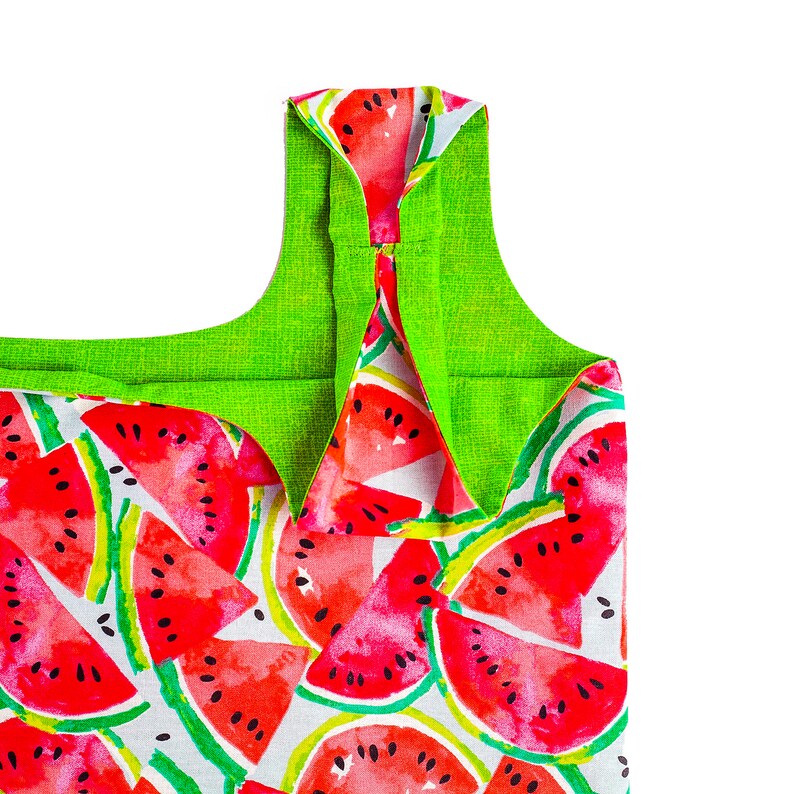 May include: A green and white reusable shopping bag with a watermelon print. The bag has a green fabric lining and a wide, flat base.