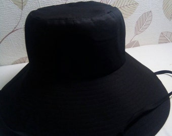 Puede incluir: Un sombrero de sol negro de ala ancha con un diseño sencillo y un cordón.