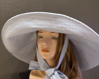A romantic wide-brim hat in soft blue and white gingham, designed for effortless elegance and timeless summer style. Cotton hat