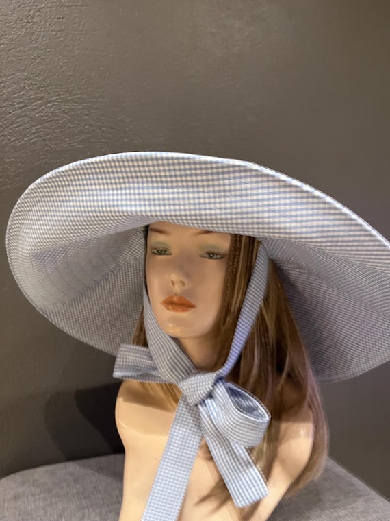 A romantic wide-brim hat in soft blue and white gingham, designed for effortless elegance and timeless summer style. Cotton hat