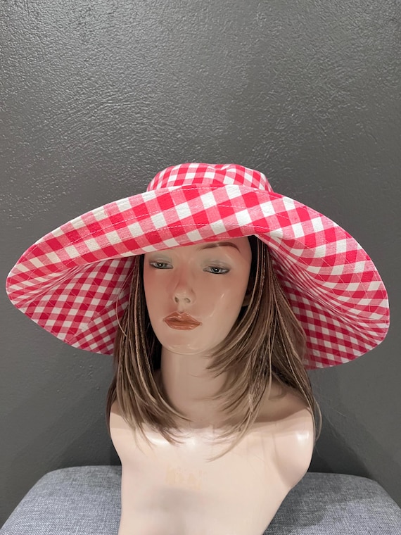 A romantic wide-brim hat in soft red and white gingham, designed for effortless elegance and timeless summer style. Cotton hat