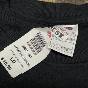 May include: A black t-shirt with a white tag that says "DEFTONES-HT COVERTON" and "380522 - 003". The tag also says "DEPT 0009 VEND 2081" and "LG". The price is $16.99.