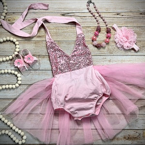 Puede incluir: Conjunto de beb&eacute; ni&ntilde;a rosa con corpi&ntilde;o de lentejuelas, falda de tul, diadema con flor rosa y collar de cuentas rosas.
