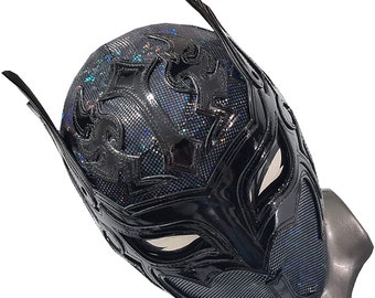 May include: Black wrestling mask with a detailed design of flames and a black and white pattern. The mask has a shiny finish and is made of a durable material.