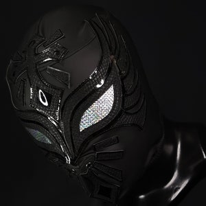 Op de afbeelding: Zwart worstelmasker met een zilveren ontwerp en iriserende ooggaten.