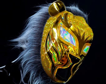May include: A gold wrestling mask with a tiger design and iridescent accents. The mask has a black eye mask with a white mesh design.