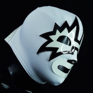 May include: A white wrestling mask with a black and white starburst design. The mask has a white mouth and eye holes.
