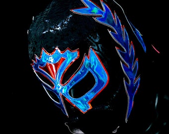 May include: A black wrestling mask with blue and red accents. The mask has a large, stylised design on the front.