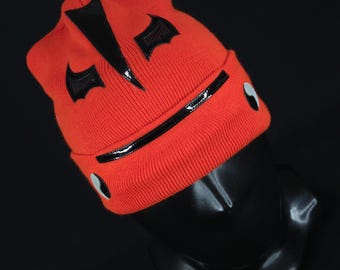 Peut inclure: Bonnet en tricot rouge avec des accents en cuir noir et un motif noir et blanc. Le bonnet a une bande en cuir noir autour du bas et un motif noir et blanc sur le devant.