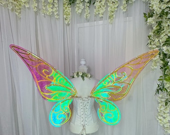 May include: A pair of iridescent butterfly wings with gold accents. The wings are pink, green, and blue with a holographic finish.