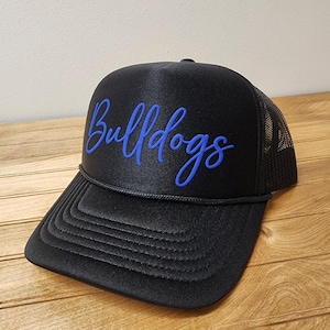 May include: Black trucker hat with a blue embroidered script that says "Bulldogs".