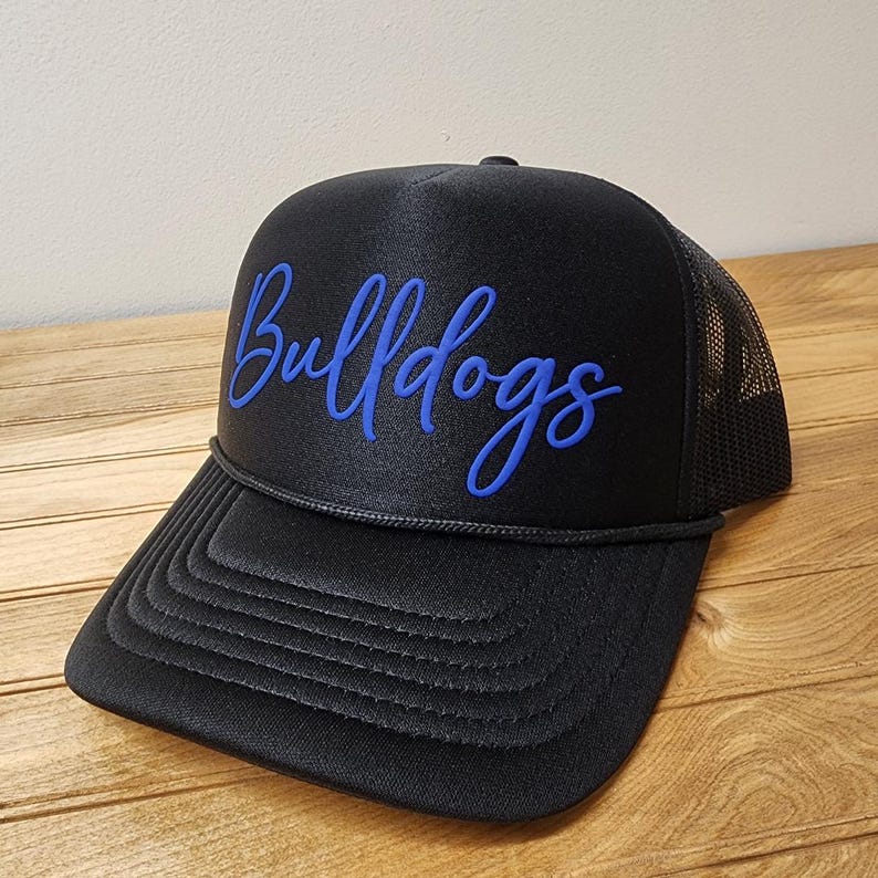 May include: Black trucker hat with a blue embroidered script that says "Bulldogs".