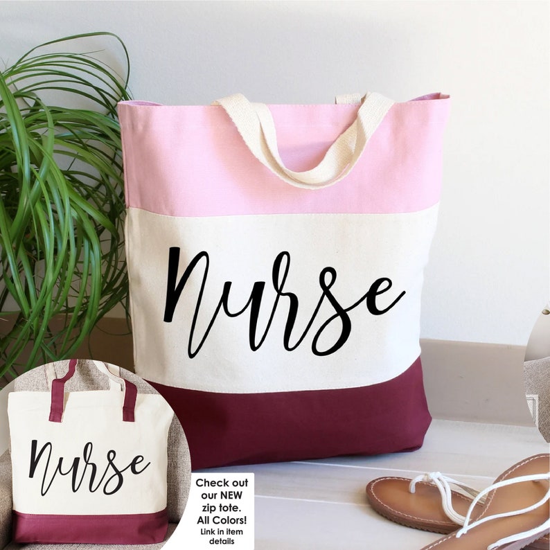 May include: A pink, white, and burgundy canvas tote bag with the word "Nurse" written in black cursive on the front.