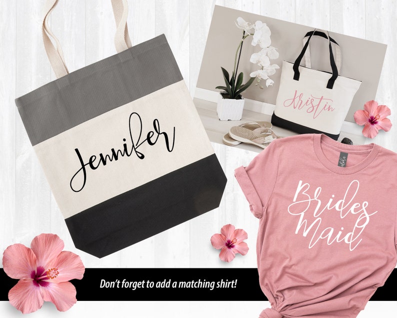 May include: Two tote bags with personalized names, "Jennifer" and "Kristin", and a pink t-shirt with the text "Bridesmaid" in white. The bags are black and white striped with a gray top. The t-shirt is a soft pink.
