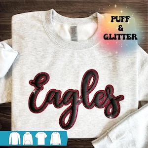 May include: Gray sweatshirt with a red and black puff and glitter "Eagles" design. The sweatshirt is available in a variety of sizes and colors.
