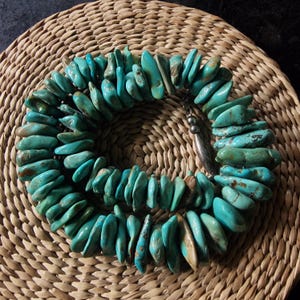 Peut inclure: Un collier turquoise composé de grosses pierres de forme irrégulière. Le collier est enfilée sur une chaîne en argent avec un fermoir en argent.