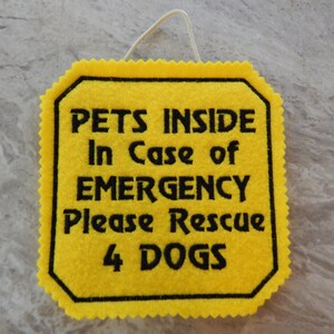 Bright yellow felt sign embroidered with PETS INSIDE In case of EMERGENCY Please Rescue 4 DOGS in bold letters with black thread. 
Has yellow felt on the back with paracord for hanging. Edges are done with pinking shears. Size approx. 5x5 square