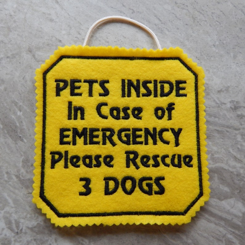 Bright yellow felt sign embroidered with PETS INSIDE In case of EMERGENCY Please Rescue 3 DOGS in bold letters with black thread. 
Has yellow felt on the back with paracord for hanging. Edges are done with pinking shears. Size approx. 5x5 square