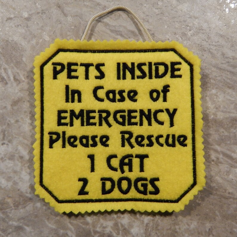 Bright yellow felt sign embroidered with PETS INSIDE In case of EMERGENCY Please Rescue 1 CAT 2 DOG in bold letters with black thread. 
Has yellow felt on the back with paracord for hanging. Edges are done with pinking shears. Size approx. 5x5 square