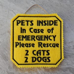Bright yellow felt sign embroidered with PETS INSIDE In case of EMERGENCY Please Rescue 2 CATS 2 DOGS in bold letters with black thread. 
Has yellow felt on the back with paracord for hanging. Edges are done with pinking shears. Size approx. 5x5 square.