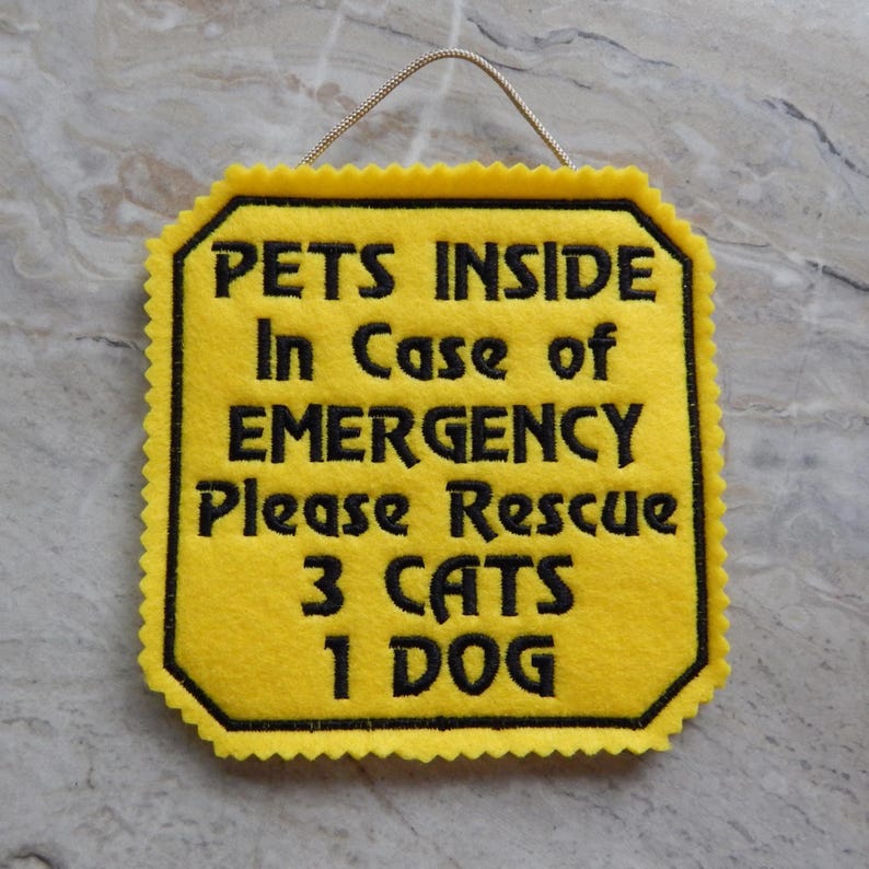 Bright yellow felt sign embroidered with PETS INSIDE In case of EMERGENCY Please Rescue 3 CATS 1 DOG in bold letters with black thread. 
Has yellow felt on the back with paracord for hanging. Edges are done with pinking shears. Size approx. 5x5 square.
