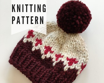 Puede incluir: Patrón de tejido para un gorro burdeos y blanco con un diseño geométrico rojo y blanco y un pompón burdeos.