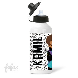 May include: White water bottle with a black lid and a black and white geometric pattern. The bottle has a cartoon illustration of a young boy with a backpack and the name "Kamil" printed in black.